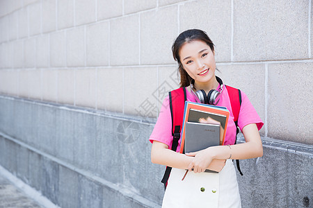 年轻女孩大学生抱着书本背景