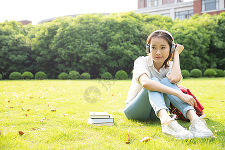 青春学生坐草地上听音乐图片