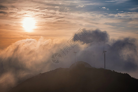 云雾缭绕的山黄昏时山顶云海中的发电风机背景