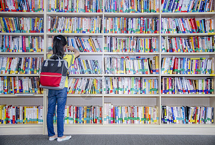 小学生站在那里孩子在图书馆看书背景