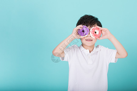 儿童小男孩手持甜甜圈玩耍图片