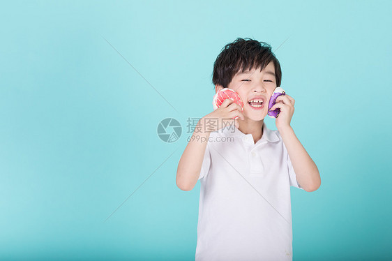 儿童小男孩手持甜甜圈玩耍图片