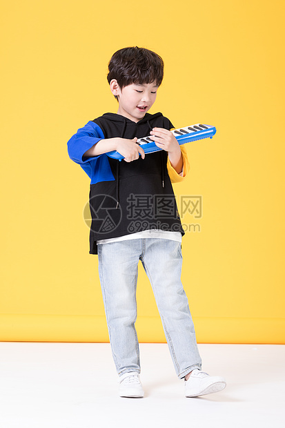 儿童小男孩手持玩具口风琴玩耍图片