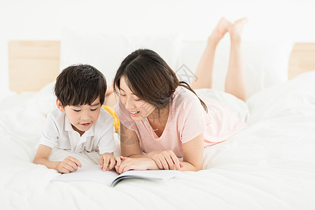 陪伴阅读妈妈陪伴儿子在床上看书背景