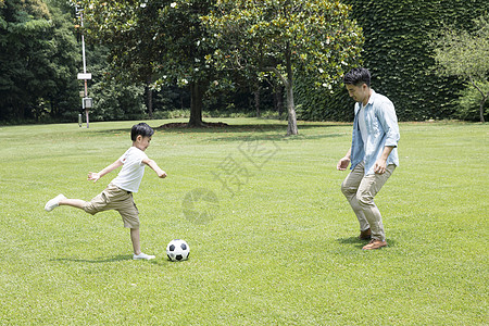 父子公园踏青踢足球背景图片
