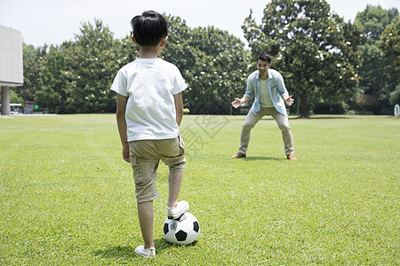 父子公园踏青踢足球图片