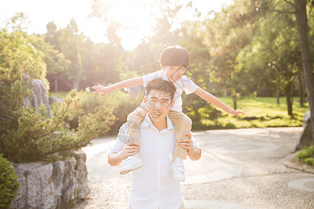 背小孩公园里父亲把孩子架到背上背景