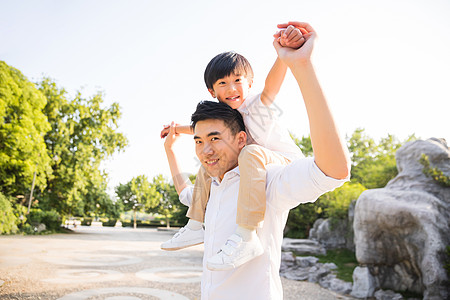 背小孩公园里父亲把孩子架到背上背景