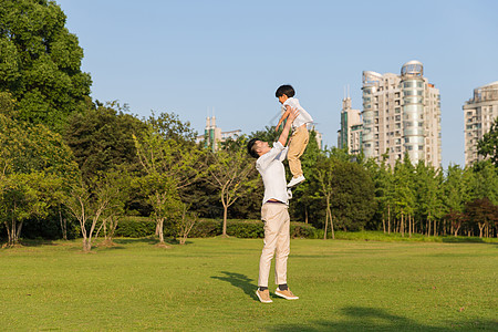 公园里父亲举起孩子背景