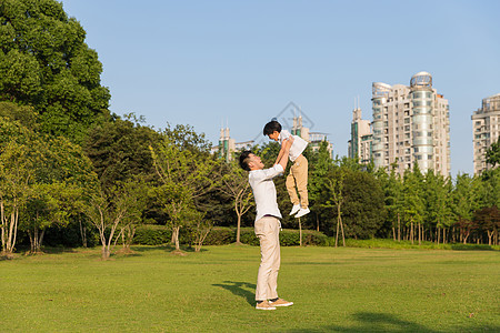 公园里父亲举起孩子背景