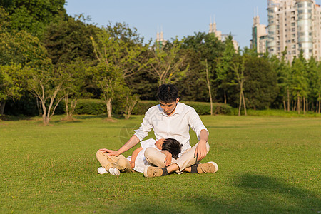 公园里孩子在父亲身边休息高清图片