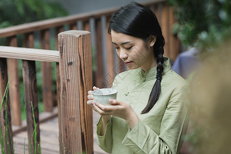 手捧茶杯的美女背景