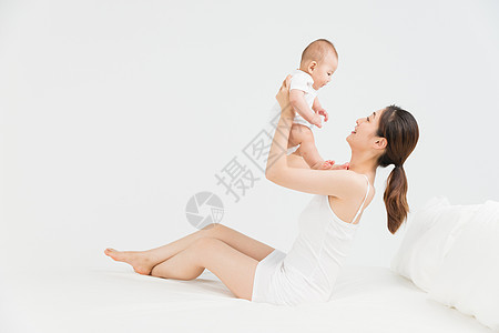 母婴床上妈妈举起宝宝背景图片