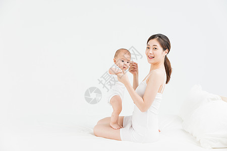 母婴床上妈妈教宝宝站立背景图片