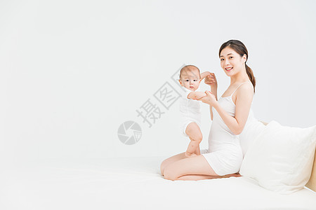 母婴床上妈妈教宝宝站立背景图片