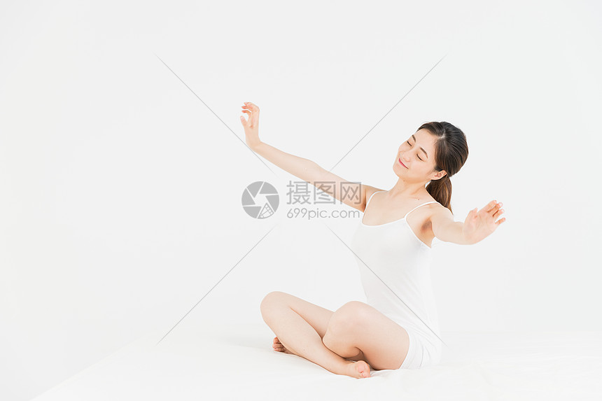 年轻女性床上伸懒腰图片