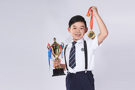 男孩拿着奖杯和奖牌图片
