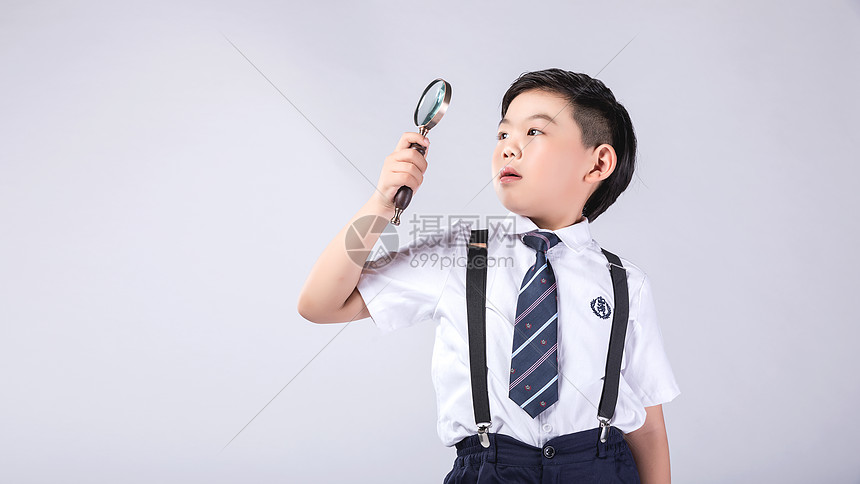 小男孩拿着放大镜探索图片