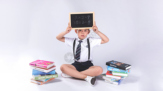 小学生学习男孩在书堆中学习背景