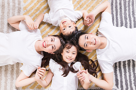 幸福的一家人躺在地毯上高清图片