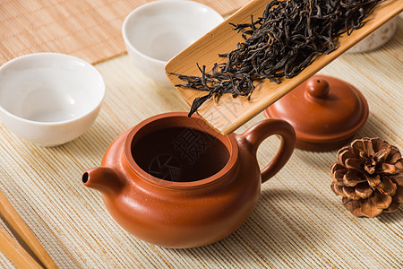 魅力的紫砂壶把茶叶投进壶中准备泡茶背景