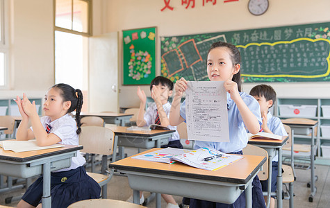 小学生做作业小学生展示试卷背景