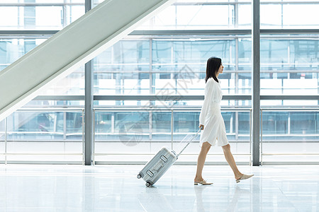 拖行李箱旅行拖着行李箱的女孩背景