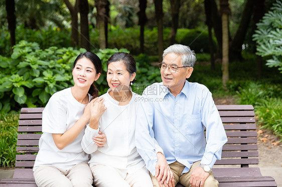 长椅上女儿陪老年夫妻聊天