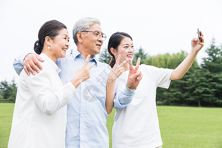 老人用手机公园里幸福一家人自拍背景