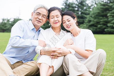 草地上幸福依靠的一家人图片