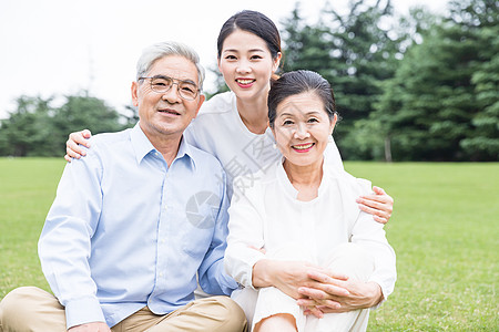 公园家庭草地上幸福依靠的一家人背景