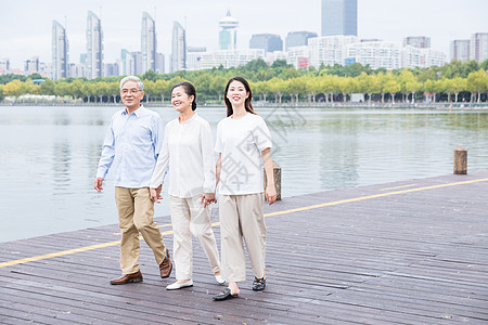 散步老人公园老年夫妻和女儿散步背景