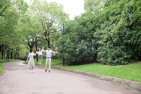 父母陪伴一家人一起在公园玩背景