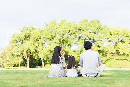 一家人坐在草坪背景