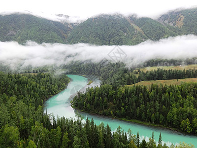 户外旅行大美新疆喀纳斯月亮湾晨雾升起时背景