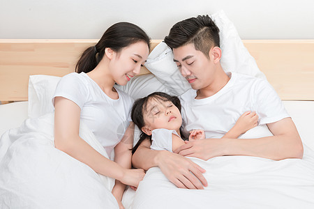躺在床上的温馨一家人相伴高清图片素材