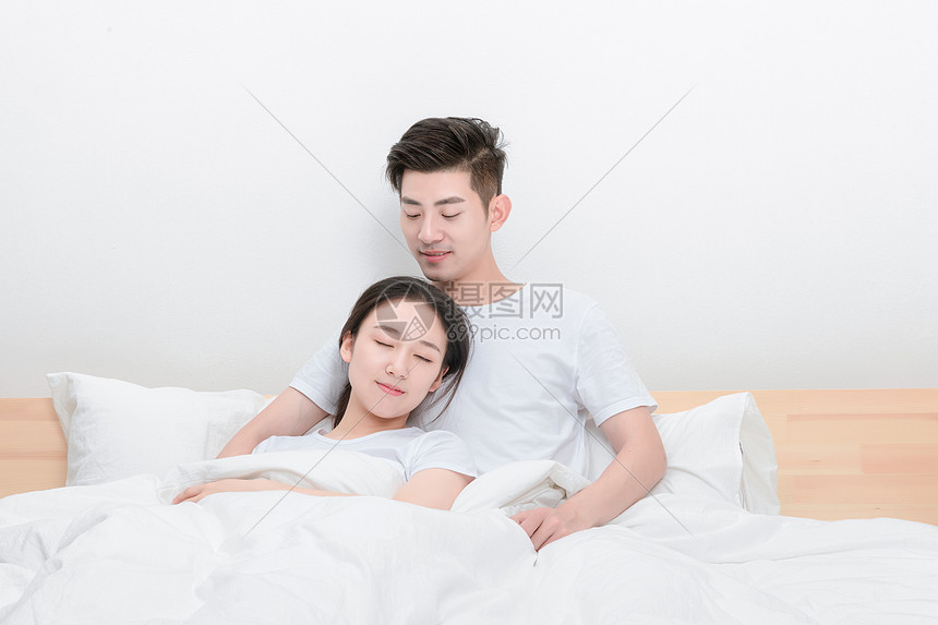 在床上放松休息的夫妻图片