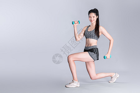 运动健身举哑铃的年轻美女背景图片