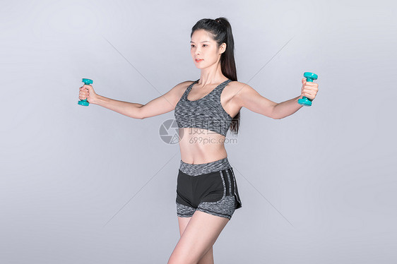 运动健身举哑铃的年轻美女图片