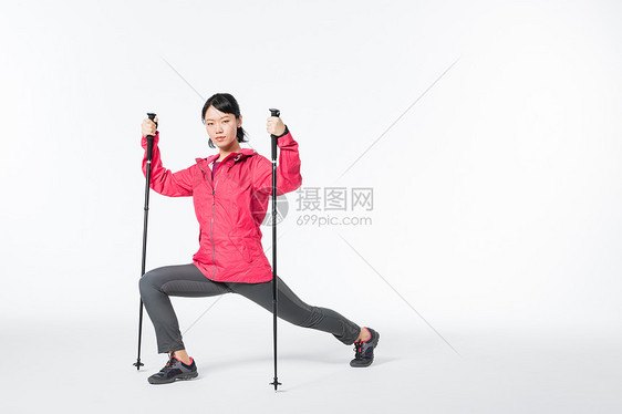 远足女性用登山杖热身图片