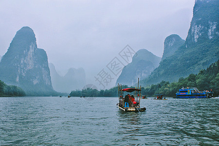 春日微雨中的桂林漓江竹筏漂流背景图片