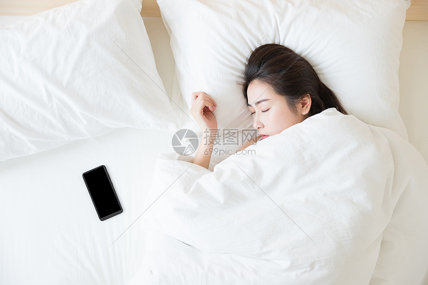 年轻女性睡觉与手机图片