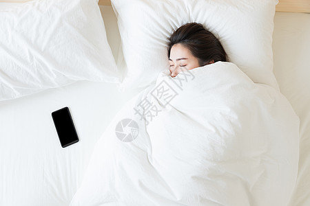 居家背景年轻女性睡觉与手机背景