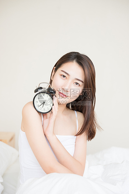 年轻女性起床与闹钟图片
