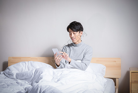 网络透明素材躺在床上玩手机的男性背景