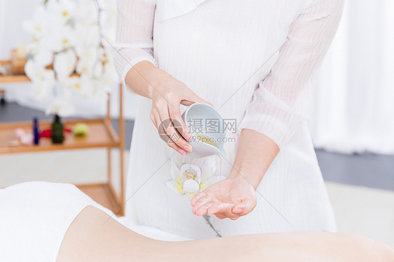 女性养生SPA倒精油特写图片