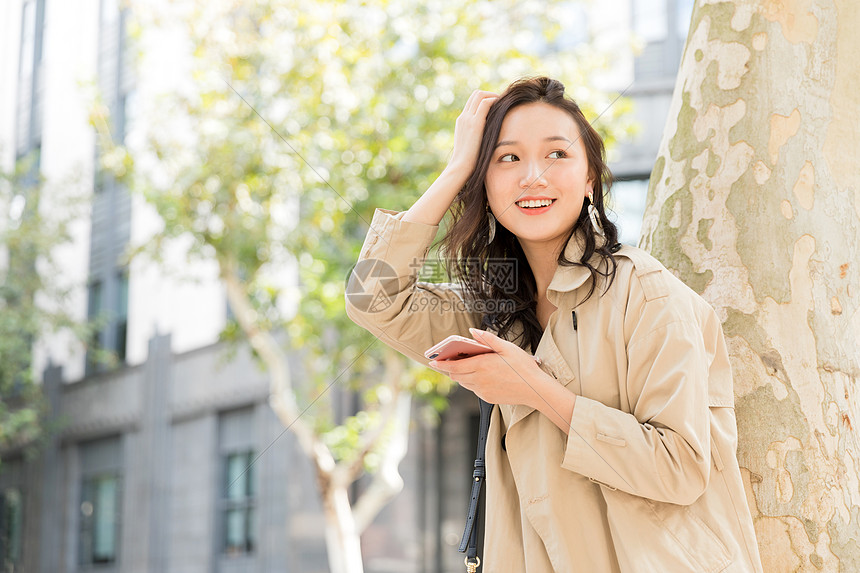 年轻美女拿手机微笑图片