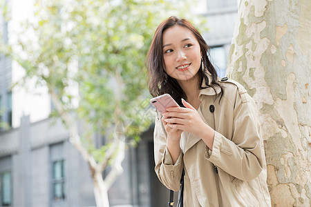 年轻美女拿手机微笑图片