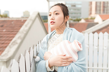 女生抱暖手袋特写背景图片