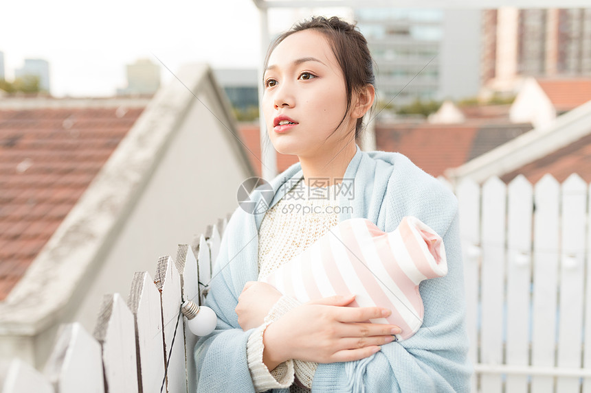 女生抱暖手袋特写图片